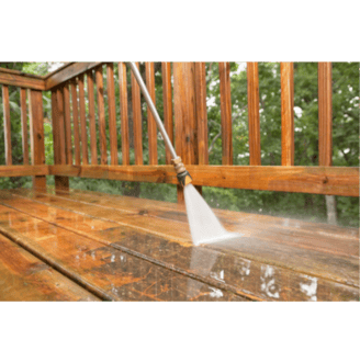 Power washing a wooden deck to remove dirt and buildup during an exterior cleaning service
