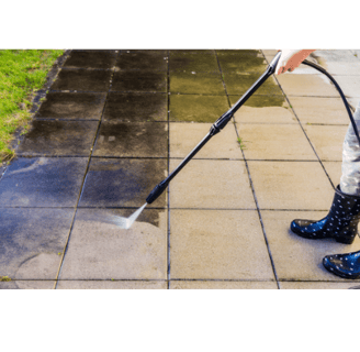 Pressure washing dirty concrete patio tiles to remove grime and restore a clean surface