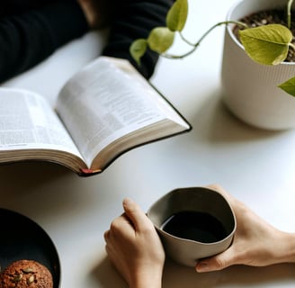 Deux personnes sont face à face, l'ambiance est détendue, avec un livre et un café