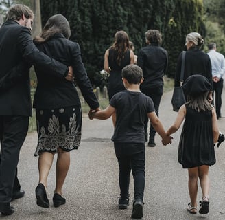 a group of people dressed in black clothing, walking into a church.