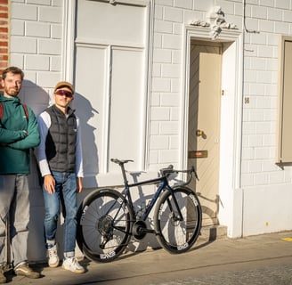 2 men standing next to a custom OPEN CYCLEbicycle