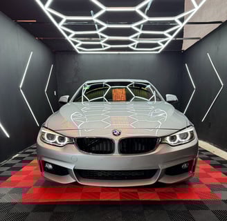 a car in a garage with a car in the background