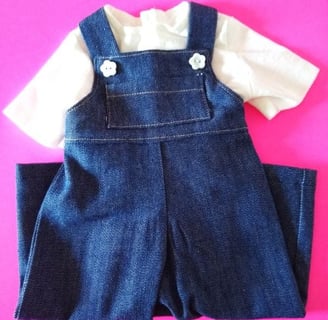 Handmade denim overalls and white T-shirt set for 18-inch dolls, displayed on a bright pink backgrou