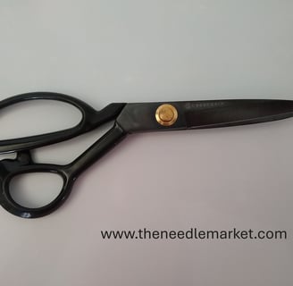 A pair of black Guggenhein sewing scissors with gold screw detail on a white background.