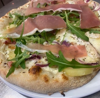 a pizza with cheese and vegetables on a plate