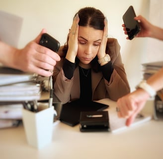 a woman sitting at a desk with her hands on her head, four hands show her watches,she seems stressed