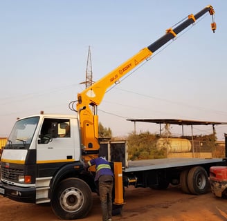 A telescopic boom truck mounted crane lifting a truck.