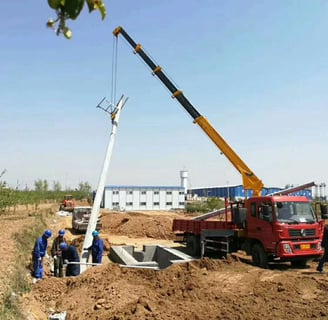 A telescopic boom truck mounted crane lifting a large object over a field.