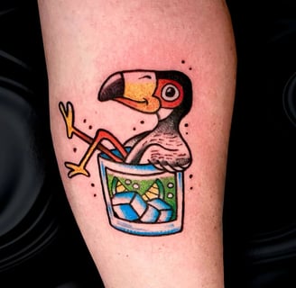 cartoonish tattoo about A chilling Toucan in a glas of drink