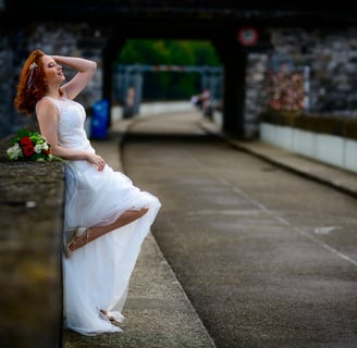 a woman in a white dress sitting on a ledge
