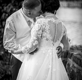a bride and groom kissing in a black and white photo