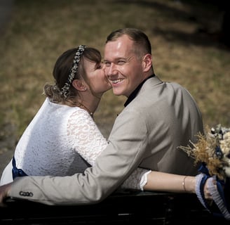 a man and woman kissing on a bench