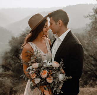 a man and woman standing in front of a mountain