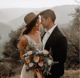 a man and woman standing in front of a mountain