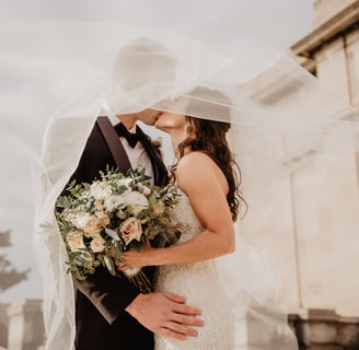 a bride and groom standing in front of a building