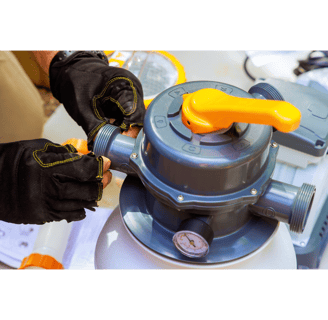 Pool tech with gloves on prepping a filtration system