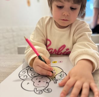 a young child is drawing on a piece of paper
