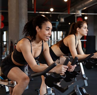 a woman is riding a stationary bike in a gym
