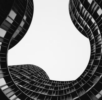 Vue d'en dessous d'un bâtiment aux murs courbés, noir et blanc