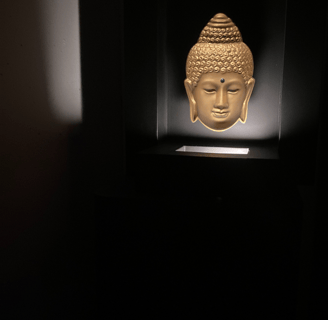 a buddha statue in a dark room with a light on it