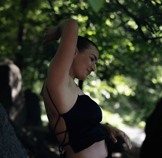 A woman dancing in a green forest