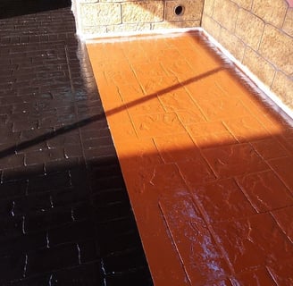 Superficie de hormigón impreso con acabado en resina de dos colores, ideal para crear contraste en áreas exteriores.