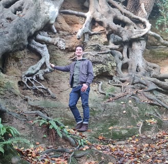 Photo of Rob Wicke, Life Coach, with tree roots in a clay bank as background. Metaphor for grounded.