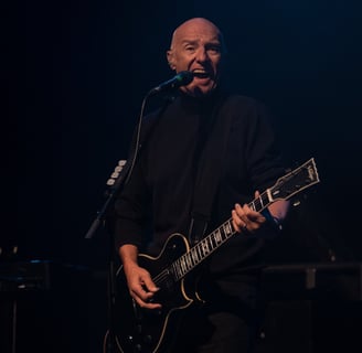 Midge Ure - singing with guitar and dark background - live at Chepstow Castle - music in Wales - Nick Langston
