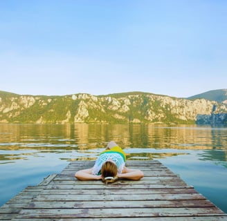 a woman laying on a dock with her hands on her head