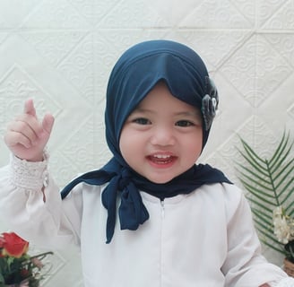 a baby wearing a blue scarf and a white shirt