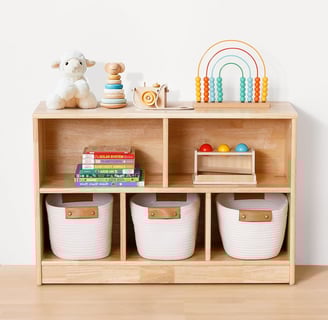 a wooden shelf with baskets and toys