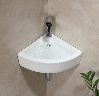 a corner sink with a plant in the corner