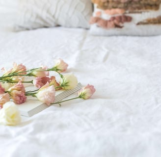 a cake with flowers on a bed in a bedroom