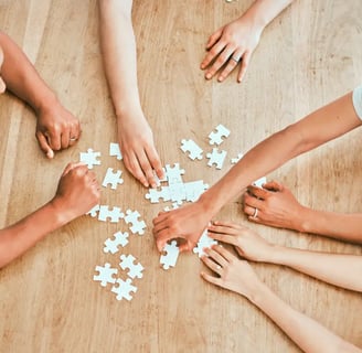 3 people solving a puzzle on a table