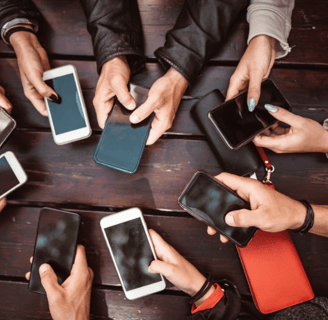 Group of people using smartphones at a table | Social media engagement and digital communication