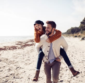 Una pareja feliz corriendo por la playa