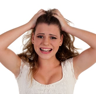Chica se lleva las manos a la cabeza, representa la frustración que genera la dependencia emocional