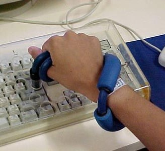 a mão de uma pessoa segurando uma tesoura e um mouse de computador