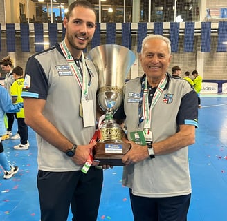 two men standing next to each other holding a trophy