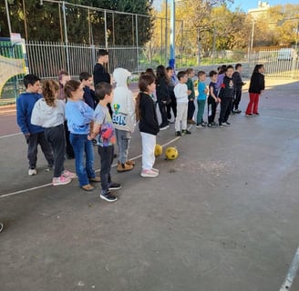 קבוצת אנשים עומדת סביב כדורי רגל לאחר פעילות ומשחק יום הולדת