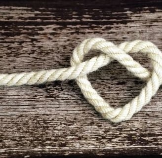 un cœur fait de corde posé sur une planche en bois   