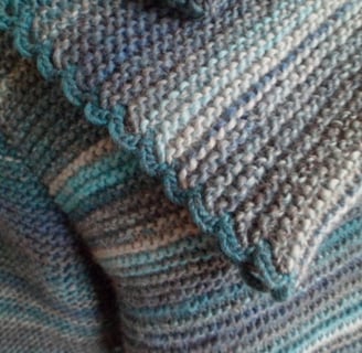 Tricot fait dans un fil dégradé de bleu et de gris 