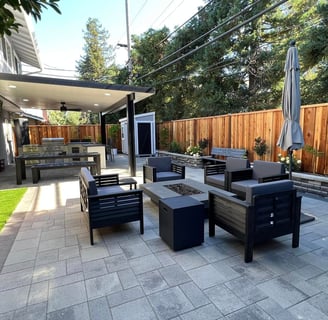 a patio with a table and chairs and a grill