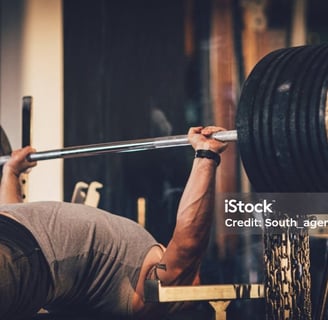 a man doing a barbell bench press in a gym