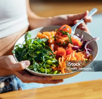 a woman holding a bowl of food in her hands