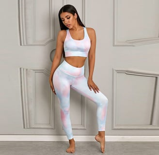 a woman in a pink and blue tie dye yoga outfit