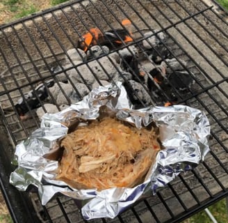 Carolina pulled chicken in foil on Charcoal grill with wood