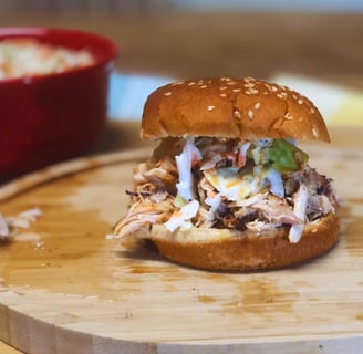 Carolina pulled chicken with coleslaw and hotsauce on a cutting board