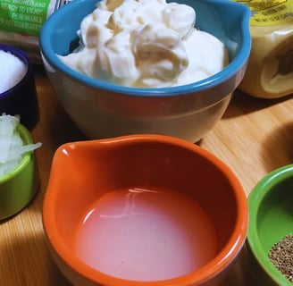 Prepared coleslaw ingredients in individual bowls, ready for mixing