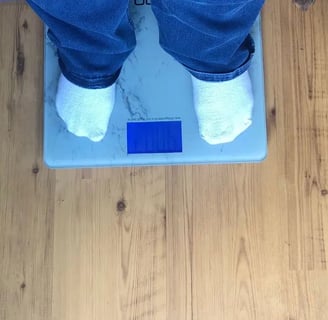 Everyday Dana on a weight scale with her dog beside her.